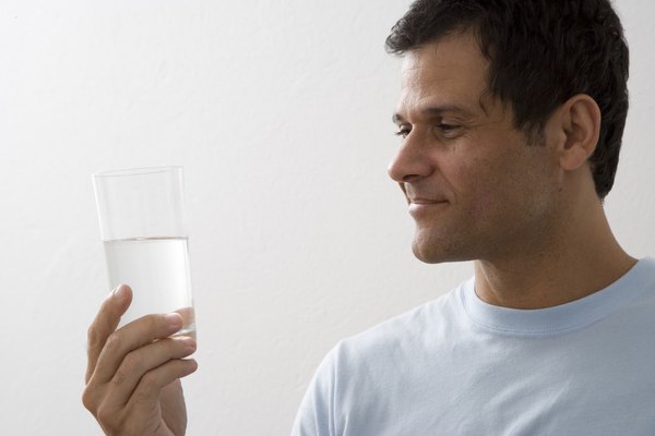 Mature man holding glass of water and smiling