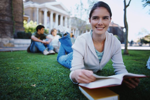 Un estudiante universitario que estudia en el césped.