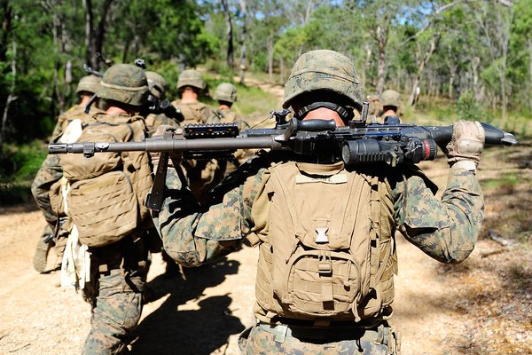 Equipo de Marines participando en ejercicios con fuego real en una base.