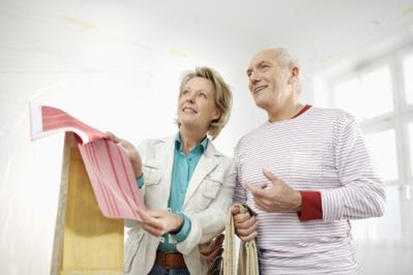 altrendo images/Stockbyte/Getty Images Los diseñadores de interiores ayudan a los clientes a seleccionar los tratamientos de paredes, muebles y decoración.