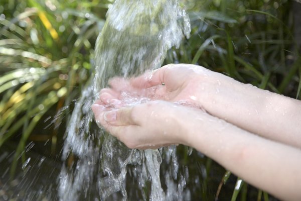Woman washing hands outside, close-up of arms