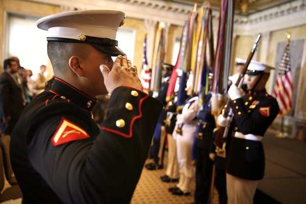 Un Marine saludando a un equipo de la guardia de honor.