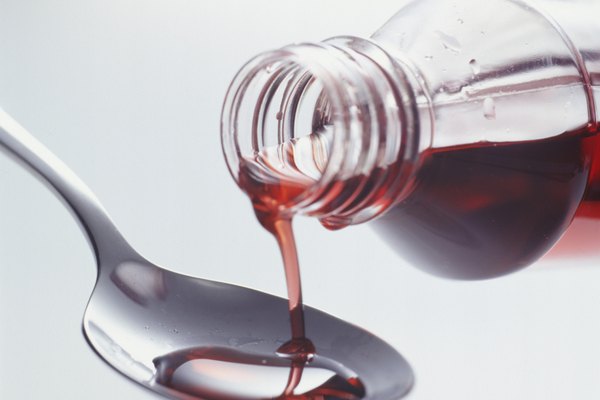 Cough syrup pouring into spoon, (Close-up)