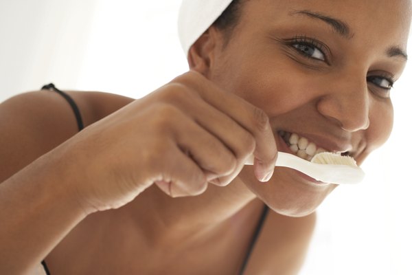Young woman brushing teeth, close-up, portrait