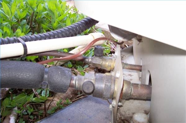 Outflow and inflow lines on an air conditioner's condenser unit.
