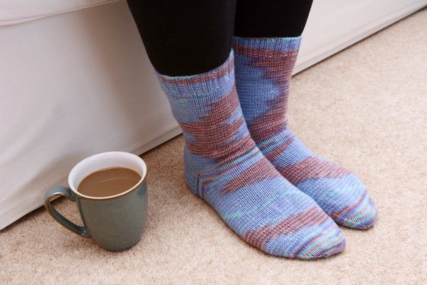 A women's knitted socks on a carpet.