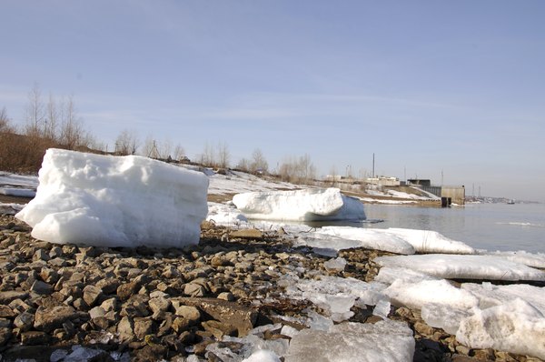 Chunks of ice and snow on the rocks of a river bed.