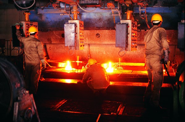 Foundry workers testing steel