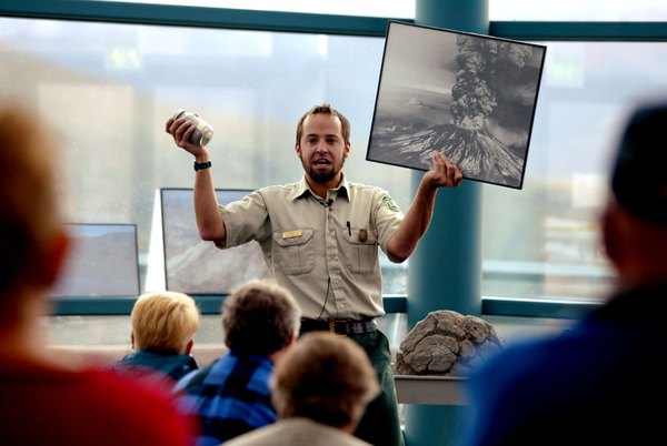 A guide holds up a photo from the 1980 eruption of Mt. St. Helen's