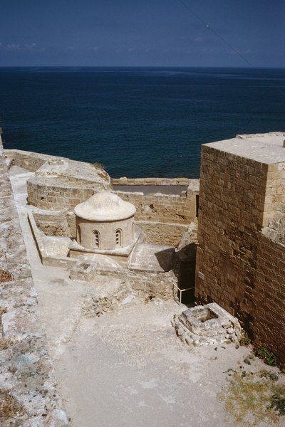 Vista parcial e angular de uma antiga fortaleza no Chipre, com o Mediterrâneo ao fundo