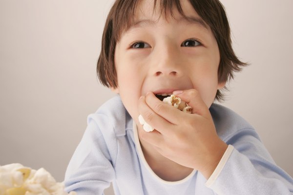Young boy eating popcorn