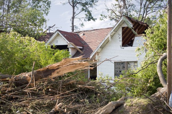 A damaged roof and windows of a home after a tornado touches down.