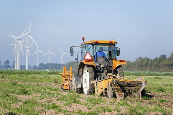 A farmer drives a tractor over a field.