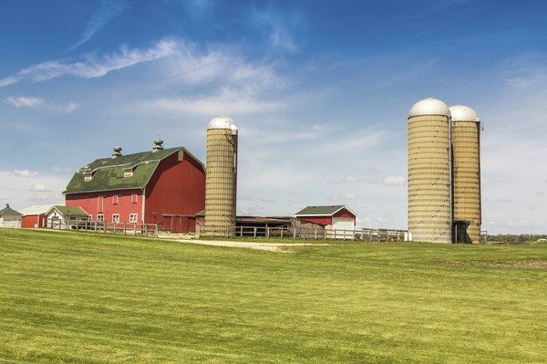 A barn and silos on farmland.