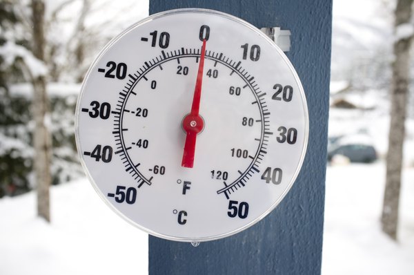 Thermometer on snow shows low temperatures - zero. Low temperatures in  degrees Celsius and fahrenheit. Cold winter weather - zero celsius thirty  two farenheit