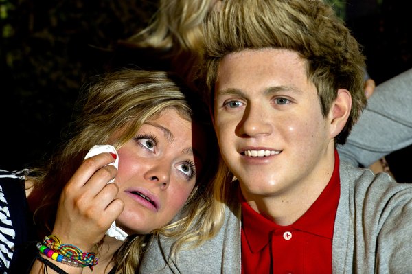Uma fã tira foto com o boneco de cera do líder do One Direction: sucesso mundial em poucos dias