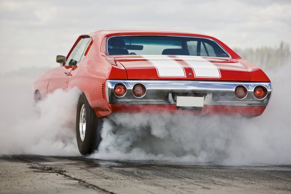 A red muscle car burning rubber