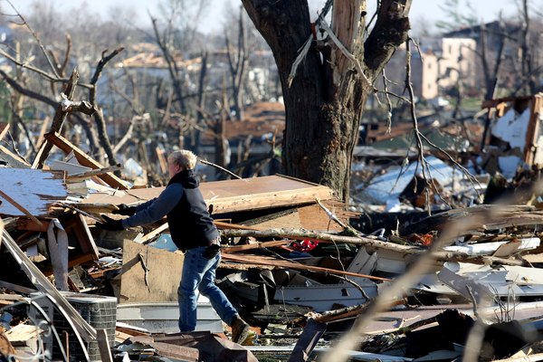 A person sorts through the debris after a tornado strikes.