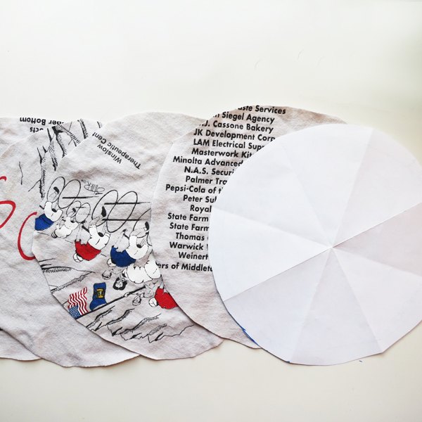 Faça um círculo de papel e use como molde para recortar quatro círculos de tecido