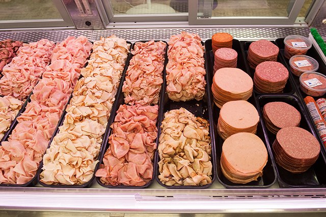 An image of meats in a deli display case.