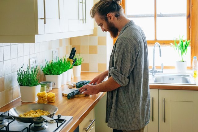 man in kitchen cooking sustainably