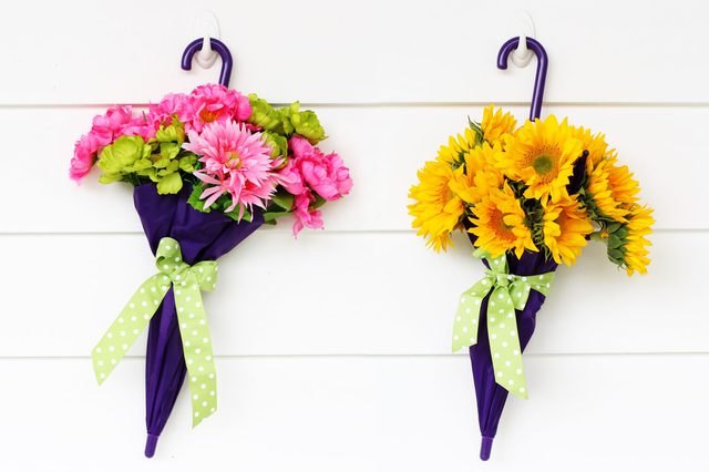 Two umbrellas filled with fragrant flowers and finished with a green bow