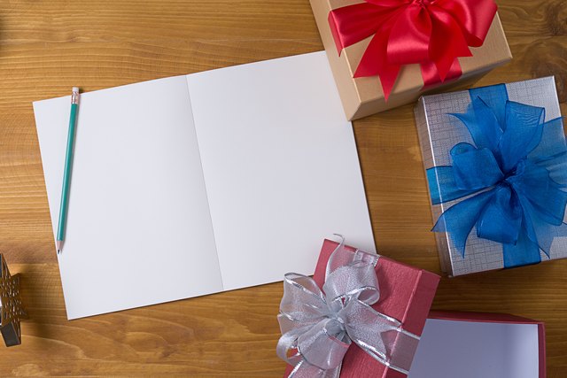 Directly Above Shot Of Gift Boxes With Blank Paper On Table