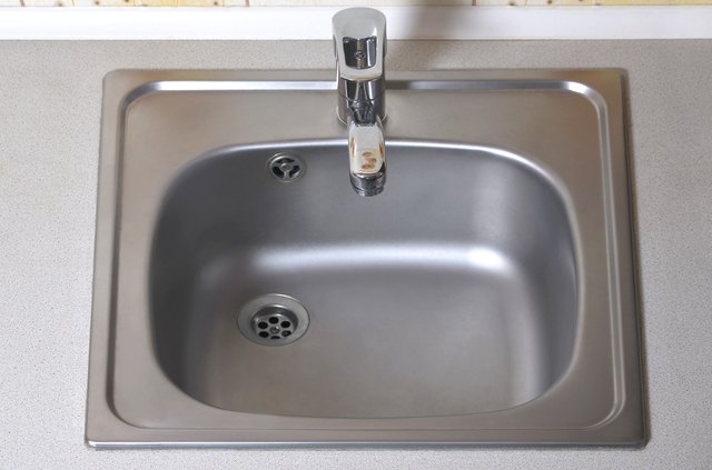 Sink with silver faucet. New equipment in kitchen counter