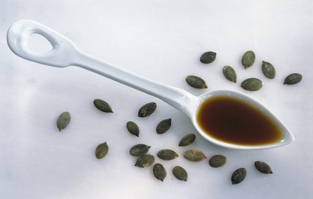 Spoonful of pumpkin oil and pumpkin seeds