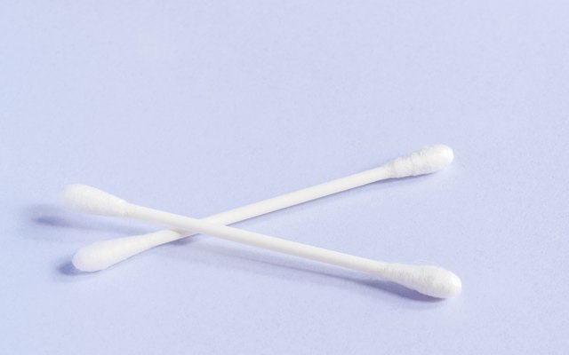 Close-Up Of Cotton Swabs Over Purple Background