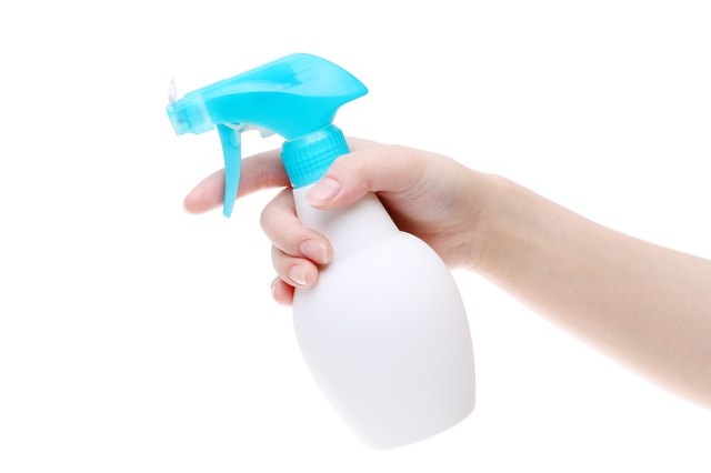Hand holding spray cleaner plastic bottle