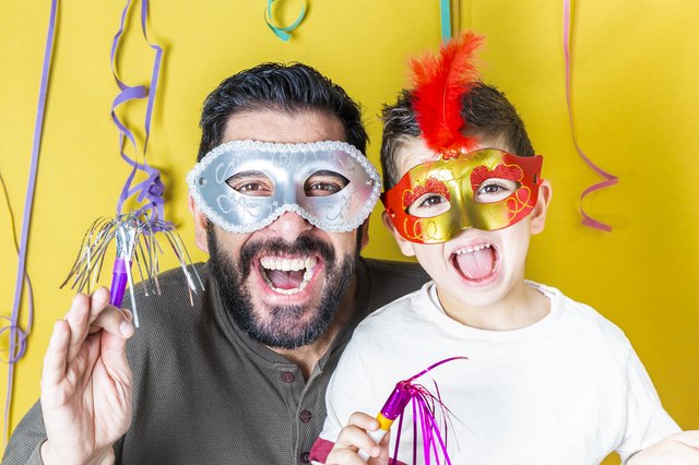 Father and son celebrating Carnival with masks