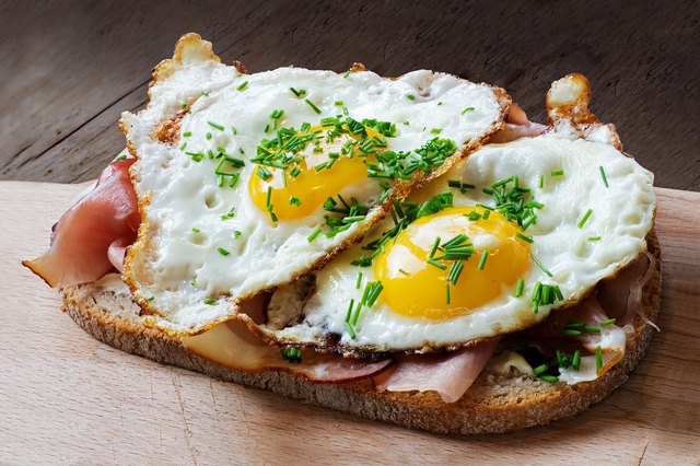 Slice of rustic bread with ham  and fried eggs