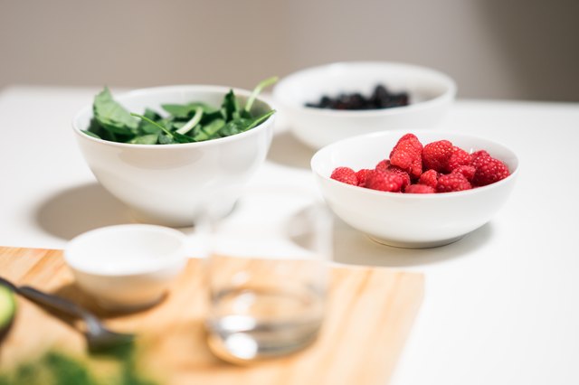 Making a healthy morning snack, a smoothie with greens and berries.