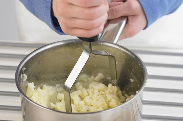 Mashing potato in a pan, close up
