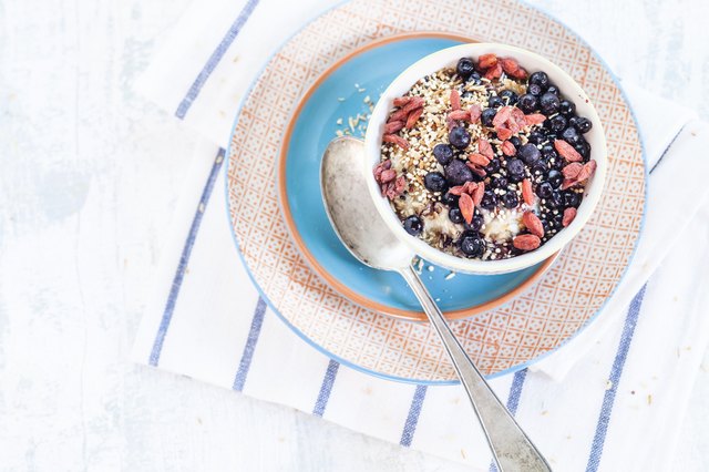 Vegan superfood breakfast with porridge, almond milk, blueberries, roasted quinoa, and goji berries