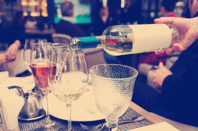 Waiting is pouring white wine, toned image