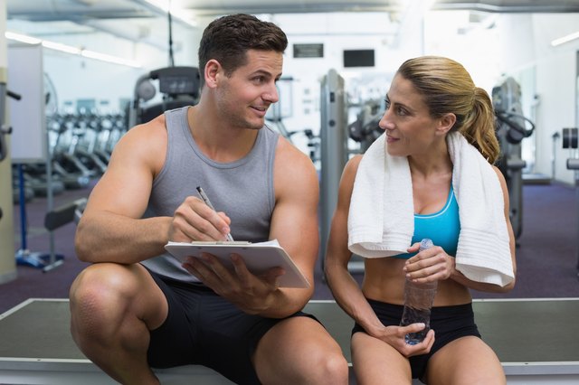 Female bodybuilder sitting with personal trainer talking
