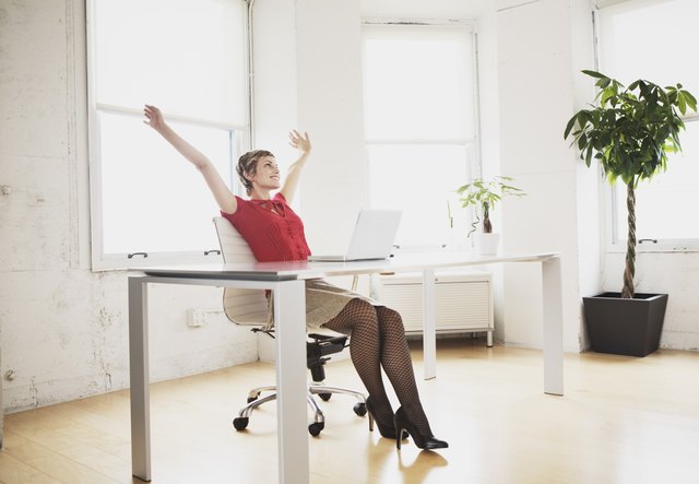 Excited young adult woman working in office