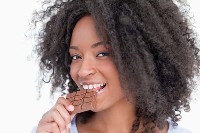 Young woman looking at the camera while eating chocolate