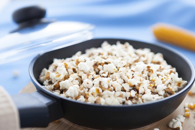 Raw corn and popcorn in a frying pan