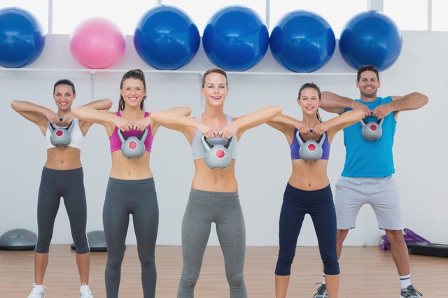 Fitness class exercising with kettlebells in gym