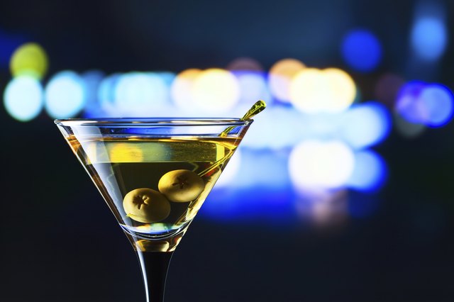 glass with martini and green olives