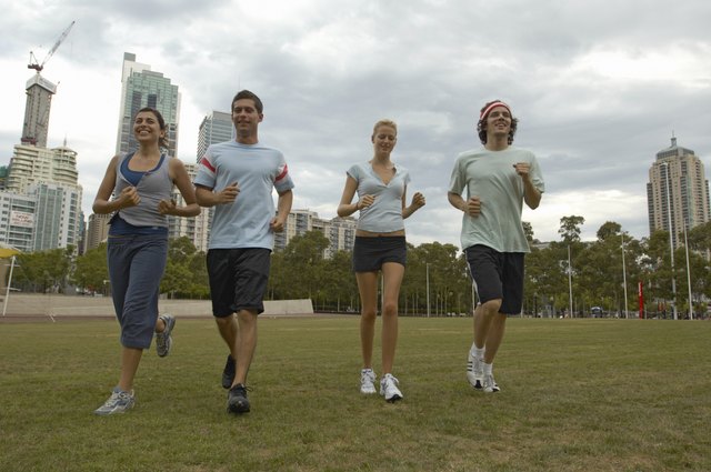 Young men and women jogging in park