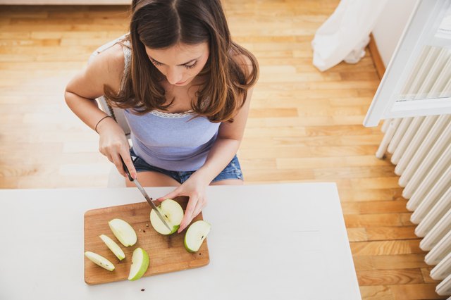 Young female cutting apple.Image from above.