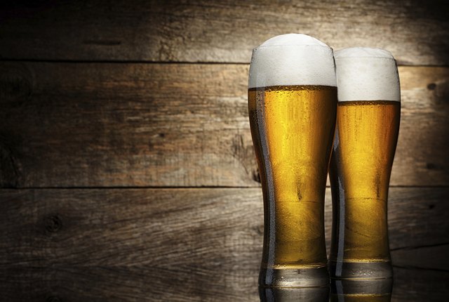 Two beer glass on a table and wooden background