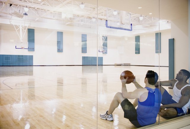 Two men sitting on basketball court