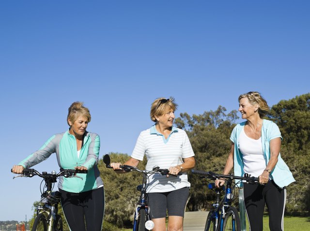 Talking women walking with bicycles