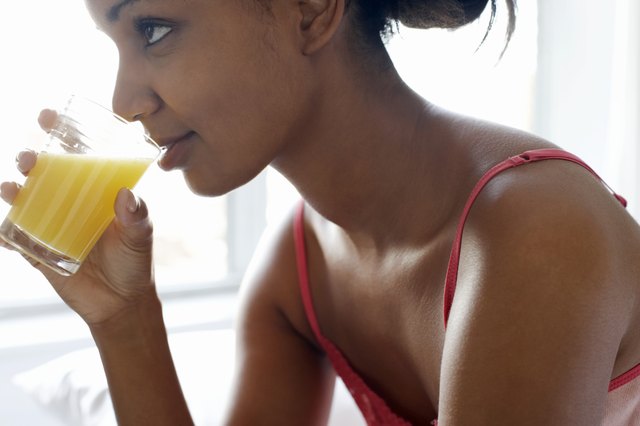Young woman drinking glass of juice, close-up