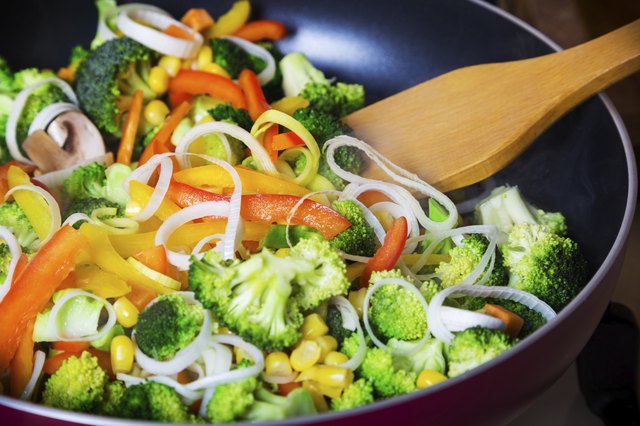 frying vegetables in pan with spatula
